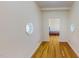 Hallway with hardwood flooring, octagon windows, and neutral paint at 1481 Country Club Rd, Roxboro, NC 27574
