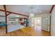 Bright, open living room and kitchen with hardwood floors, stainless steel refrigerator, and stylish chandelier at 1481 Country Club Rd, Roxboro, NC 27574