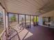 View of a screened-in porch with brown floors, a ceiling fan, and outdoor access at 1481 Country Club Rd, Roxboro, NC 27574
