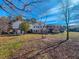 Expansive backyard view of a two-story home with a deck, showcasing the tranquil and private setting at 1481 Country Club Rd, Roxboro, NC 27574