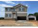 New two-story home with neutral siding, double hung windows, and two car garage on a sunny day at 15 Atherton Circle, Angier, NC 27501