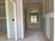 Unfinished hallway with exposed beams and light coming from the sliding glass doors in the distance at 15 Atherton Circle, Angier, NC 27501