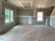 An unfinished living room with drywall awaiting transformation, with a window and recessed lighting in ceiling at 15 Atherton Circle, Angier, NC 27501