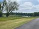 Scenic water view showcasing a serene pond surrounded by lush trees and a grassy shoreline at 15 Atherton Circle, Angier, NC 27501