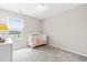 A serene Bedroom features a white crib, neutral decor, and calming views of the outdoors at 1613 Clayfire Dr, Cary, NC 27519