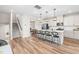 Open-concept living space with stairs, kitchen island, hardwood floors, and modern lighting at 1613 Clayfire Dr, Cary, NC 27519