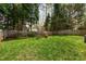 Spacious fenced backyard with mature trees and lush green lawn, perfect for outdoor activities at 200 Adefield Ln, Holly Springs, NC 27540