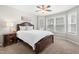 Bright bedroom featuring a ceiling fan, large windows, and a spacious layout with neutral carpet and walls at 200 Adefield Ln, Holly Springs, NC 27540