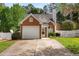 Charming brick and vinyl home featuring an attached garage, manicured lawn and mature trees at 200 Adefield Ln, Holly Springs, NC 27540