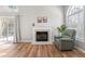 A comfortable living room featuring a fireplace, hardwood floors, and access to the backyard at 200 Adefield Ln, Holly Springs, NC 27540