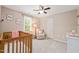 Bedroom with a crib, chair, window, and ceiling fan at 2032 Stoneglen Ln, Raleigh, NC 27603