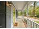 Covered front porch with concrete flooring, white railings, and a yellow front door with a 
