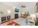 Spacious living room featuring hardwood floors, a fireplace, ceiling fan, and neutral decor at 2032 Stoneglen Ln, Raleigh, NC 27603