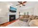 Cozy living room with a fireplace, hardwood floors, ceiling fan, and a comfortable sectional sofa at 2032 Stoneglen Ln, Raleigh, NC 27603