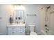 Bathroom featuring a shower-tub combo with white tile, light gray walls and vanity and stainless steel hardware at 208 Evanview Ct, Apex, NC 27523