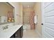 Bathroom with a dark wood vanity, red patterned shower curtain and neutral wall and floor tile at 208 Evanview Ct, Apex, NC 27523