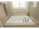 Stylish bathtub with neutral tile surround, modern fixtures, and a view of the seamless glass shower at 208 Evanview Ct, Apex, NC 27523