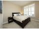 Cozy bedroom with neutral walls, a comfortable bed, carpet, plantation shutters, and a view of the outdoors at 208 Evanview Ct, Apex, NC 27523