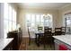Cozy dining room with hardwood floors, plantation shutters, decorative rug, chandelier, and plenty of natural light at 208 Evanview Ct, Apex, NC 27523