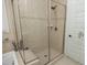 Modern glass-enclosed walk-in shower featuring neutral tile surround, built-in bench, and sleek fixtures at 208 Evanview Ct, Apex, NC 27523