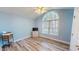 This bedroom has blue walls, wood floors, and a large window with natural light at 2105 Antioch Church Rd, Timberlake, NC 27583