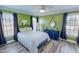 This bedroom features green walls, wood floors, and two windows with natural light at 2105 Antioch Church Rd, Timberlake, NC 27583