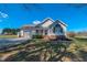 Beautifully landscaped white home featuring a covered front porch, arched window, and attached garage at 2105 Antioch Church Rd, Timberlake, NC 27583