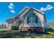 Charming white home with a large arched window and a well-manicured lawn with colorful spring plants at 2105 Antioch Church Rd, Timberlake, NC 27583