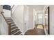 Hallway with wood floors leading to the front door and a staircase with white risers and wooden treads at 213 Umstead St, Sanford, NC 27330