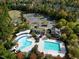 Aerial view of a community park, pool, clubhouse, parking, and playground surrounded by trees at 217 Waterford Lake Dr, Cary, NC 27519