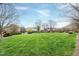 Expansive green lawn bordered by trees with neighborhood buildings in the distance at 217 Waterford Lake Dr, Cary, NC 27519