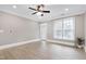 Bright living room featuring wood-look floors, a ceiling fan, and natural light from a large window at 217 Waterford Lake Dr, Cary, NC 27519