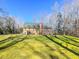 Expansive backyard with lush green lawn, mature trees, and a brick home exterior at 2440 Helena Moriah Rd, Timberlake, NC 27583