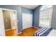 Comfortable bedroom featuring hardwood floors, a double closet, and a large window at 2440 Helena Moriah Rd, Timberlake, NC 27583