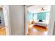 View of the bright bedroom with a ceiling fan, two windows, and hardwood floors seen through the doorway at 2440 Helena Moriah Rd, Timberlake, NC 27583