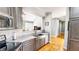 Well-lit kitchen featuring stainless steel appliances and sink, with a view to an adjacent living area at 2440 Helena Moriah Rd, Timberlake, NC 27583