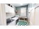 Bright laundry room with checkerboard flooring, washer, dryer, cabinets and hanging rack at 2440 Helena Moriah Rd, Timberlake, NC 27583