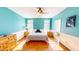Bedroom showcasing vibrant turquoise walls, wood floors, and a connecting bathroom at 2440 Helena Moriah Rd, Timberlake, NC 27583