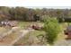 Aerial view of the house surrounded by trees, a lush green lawn and outbuildings at 2563 Millbrook Dr, Haw River, NC 27258