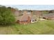 Back view of brick house with a large, well-manicured lawn, and mature trees at 2563 Millbrook Dr, Haw River, NC 27258