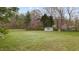 A large, well-maintained backyard with a shed, mature trees, and a partially fenced perimeter at 2563 Millbrook Dr, Haw River, NC 27258