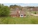 Back view of brick house with a large, well-manicured lawn and mature trees at 2563 Millbrook Dr, Haw River, NC 27258