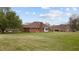A sprawling backyard with lush green grass and mature trees offering privacy and space for outdoor activities at 2563 Millbrook Dr, Haw River, NC 27258
