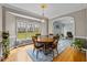 Cozy dining room with hardwood floors, large windows, and a round wooden table with chairs at 2563 Millbrook Dr, Haw River, NC 27258