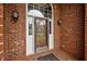 Elegant brick home entrance with decorative glass door and sidelights at 2563 Millbrook Dr, Haw River, NC 27258