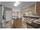 Spacious kitchen featuring hardwood floors, wooden cabinets, granite countertops, and a white door at 2563 Millbrook Dr, Haw River, NC 27258