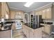 Well-lit kitchen with wooden cabinets, granite countertops, stainless steel refrigerator, and kitchen island at 2563 Millbrook Dr, Haw River, NC 27258