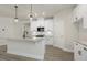 Elegant kitchen featuring white cabinets, granite countertops, stainless appliances, and sleek pendant lighting at 280 Providence Creek Dr, Fuquay Varina, NC 27526