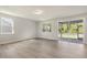 Open living room with hardwood floors, large windows and access to outdoor patio at 280 Providence Creek Dr, Fuquay Varina, NC 27526