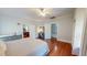 Bright bedroom featuring hardwood floors, ceiling fan, and doorways leading to office and stairway at 308 College St, Oxford, NC 27565